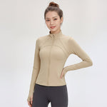 Woman wearing a beige FormFlex_High-Neck_Jacket_athletic jacket on a white background