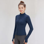 Woman wearing a FormFlex_High-Neck_Jacket in navy on a light gray background