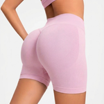 Pink athletic shorts worn by a person on a light gray background