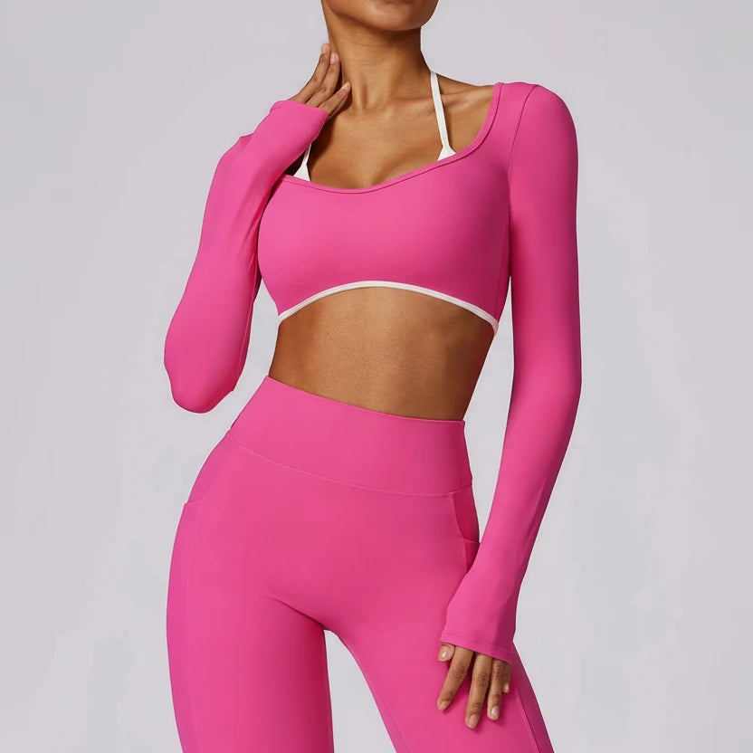 Person wearing a SoftForm™ Long-Sleeve Crop pink athletic outfit on a gray background