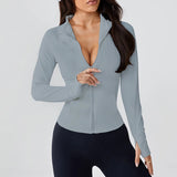 Woman wearing SoftForm™ Long-Sleeve Jacket in light gray zip-up top and black leggings on a white background