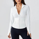 Woman wearing a black SoftForm™ Long-Sleeve Jacket  with a deep neckline on a gray background with black leggings