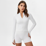 Woman wearing a  SoftForm™ Long-Sleeve Top white long-sleeve top and shorts set on a light gray background