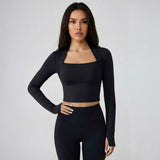 A woman wearing a SoftForm_Long-Sleeve_Yoga_Top_black athletic outfit on a plain background