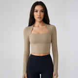 Woman wearing a SoftForm_Long-Sleeve_Yoga_Top_taupe long-sleeve top and black leggings on a gray background