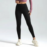 Person wearing black leggings with a plain background