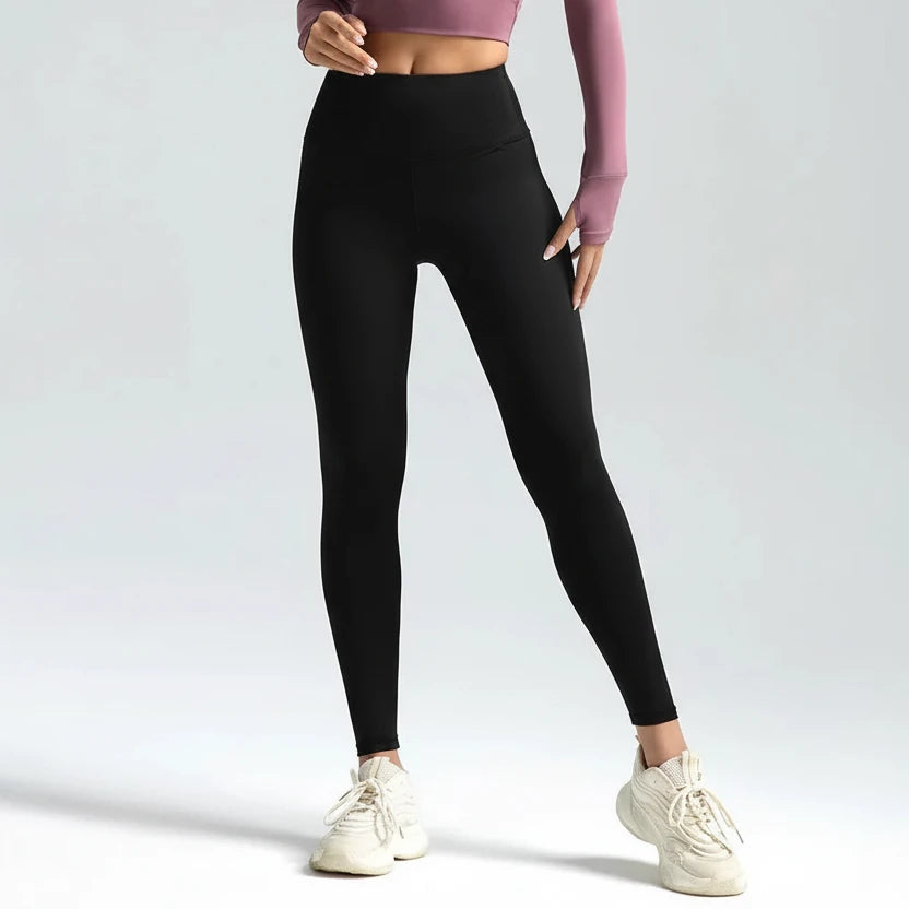 Person wearing black leggings with a plain background