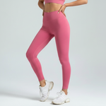 Person wearing pink leggings and white sneakers on a light gray background