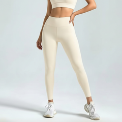 Person wearing beige SoftForm_Sculpt  leggings and a matching top on a light gray background