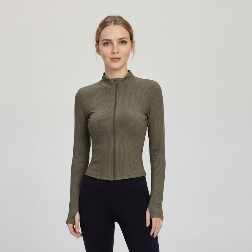 Woman wearing a SoftForm™ Slim Jacket sage green athletic jacket and black leggings on a light gray background