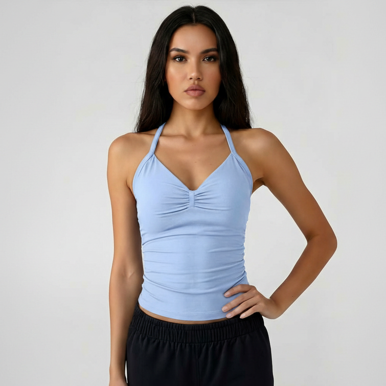 Woman wearing a light blue SoftForm™ Tank top and black shorts on a plain background