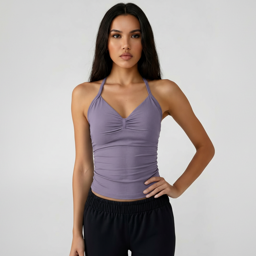 Woman wearing a purple SoftForm™ Tank top and black shorts on a plain background