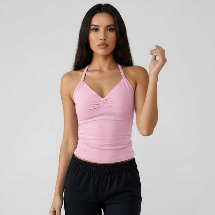 Woman wearing a pink SoftForm™ Tank top and black pants on a light gray background