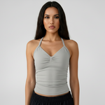 Woman wearing a SoftForm™ Tank_stone top and black shorts on a white background