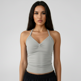 Woman wearing a SoftForm™ Tank_stone top and black shorts on a white background