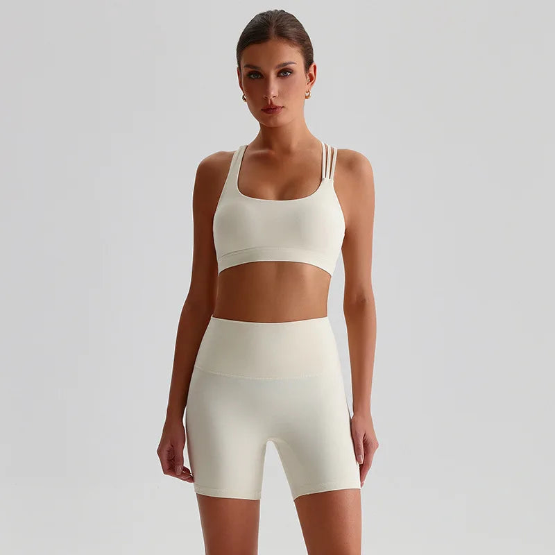 Woman wearing a white SoftForm™ Yoga Set bra and shorts set on a light gray background