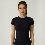 Woman wearing a black SoftForm_Yoga_Shirt on a plain background