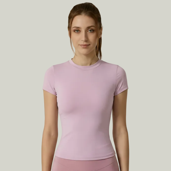 Woman wearing a pink SoftForm_Yoga_Shirt outfit on a plain background