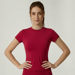 Woman wearing a red SoftForm_Yoga_Shirt on a plain background