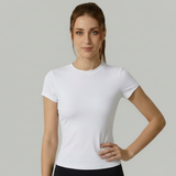 Woman wearing a white SoftForm_Yoga_Shirt against a plain background